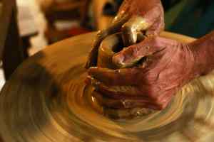 poterie les mains d'un potier en train de tourner un vase sur le tour